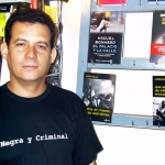 Posando para la cámara del librero Paco Camarasa, en la librería Negra y Criminal. Barcelona, España, 2004.